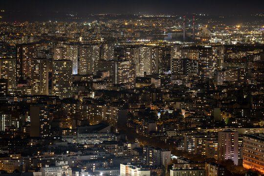 Aerial view of a dazzling urban expanse where the city's lights paint a mesmerizing tableau, contrasting with the dark sky, Paris, Ile-de-France, France.