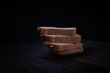 Sliced buckwheat bread on dark wooden background.