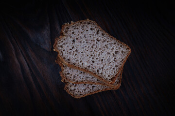 Sliced buckwheat bread on dark wooden background.