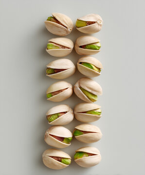 Two Rows of Pistachio Nuts on White Background &ndash; Minimalist Food Concept