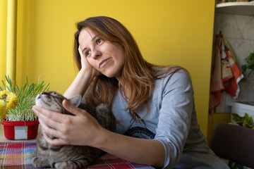 A woman with her cat friend at the table in the morning