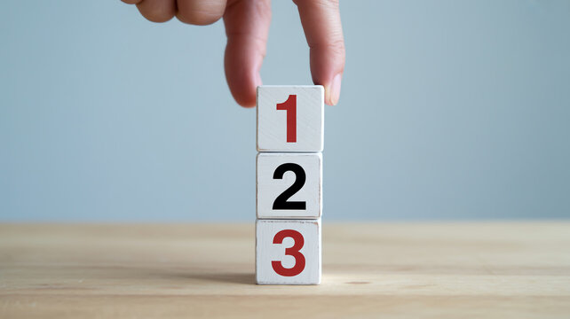 Hand stacking blocks with numbers 1 2 3