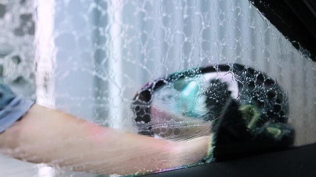 car wash, wiping the windshield with a cloth, showing careful car cleaning, maintenance, and professional car wash service