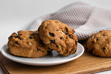 Closeup photo homemade cookies with nuts and raisins on a wooden board. For food blogs, bakery ads and recipe content.