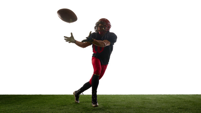 Football player catching descending ball with concentrated emotion. Concept of skill training, body in motion, coaching slides, sport education, app mockups, advertising layouts.