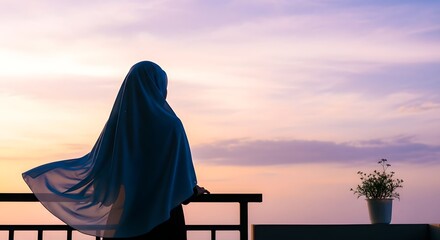 A person wearing a hijab standing on a balcony and gazing at a colorful sunset sky with a potted plant nearby, creating a peaceful and contemplative scene