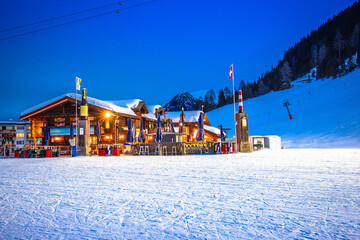 Idyllic mountain town of Davos in Swiss Alps ski slope and apres ski lodge evening view