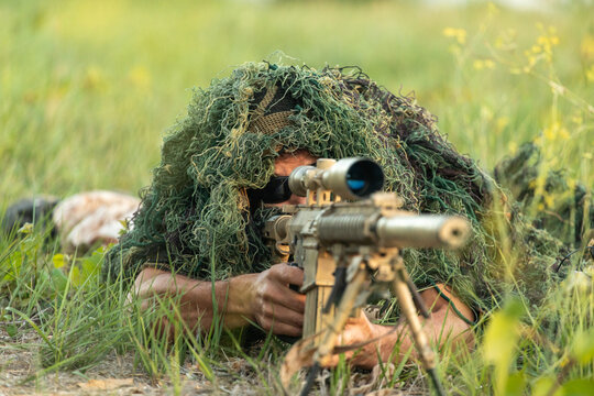 Sniper in camouflage suit during airsoft training