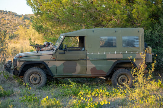 Camouflaged military operator with sniper rifle in nature