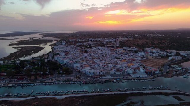 aerial panoramic shot around Fuseta fishing village at sunset, near ria formosa natural reserve on the Algarve Coast near Faro, Portugal
