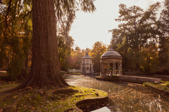 Autumn backlit view of a kiosk and small pavilion next to a lake