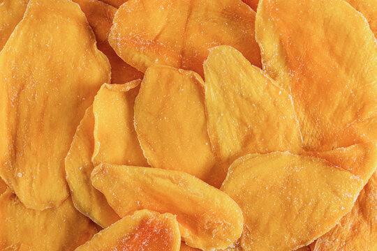 Top view of dried mango slices in a vibrant orange hue