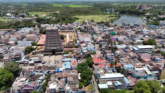 Beautiful aerial footage of Tenkasi&rsquo;s Kasi Viswanathar Temple complex surrounded by colorful town structures and vast green fields on a bright sunny day in South India.