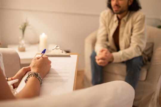 Psychologist taking notes during therapy session