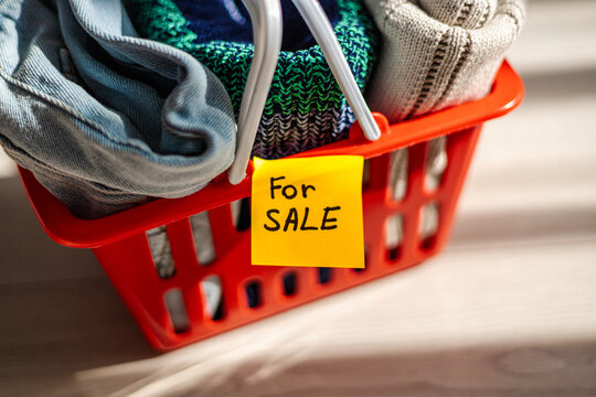 Shopping basket with clothes for sale sign