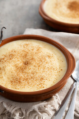 Creamy homemade Spanish custard served in a bowl on wooden table