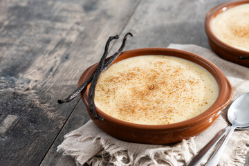 Creamy homemade Spanish custard served in a bowl on wooden table. Copy space