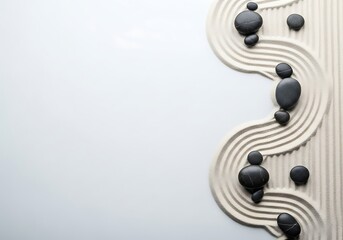 Black stones arranged on textured white surface with waves  
