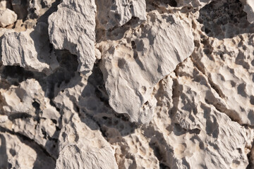 Tough coastal rocks are under bright sunlight, top view. Natural background photo