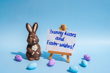 Chocolate bunny and Easter greeting card on blue background