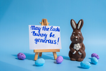 Chocolate bunny with Easter greeting on blue background