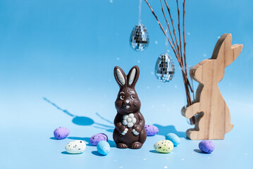 Chocolate Easter bunny and pastel eggs with blue background