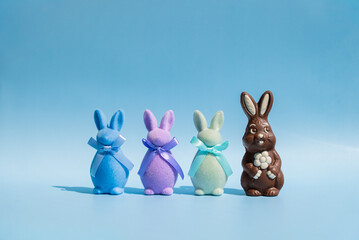 Chocolate and plush Easter bunnies on blue background
