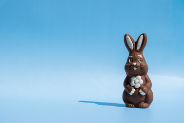 Chocolate Easter bunny on blue background with copy space