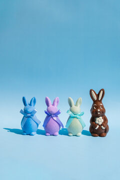 Chocolate and colorful bunnies on blue background