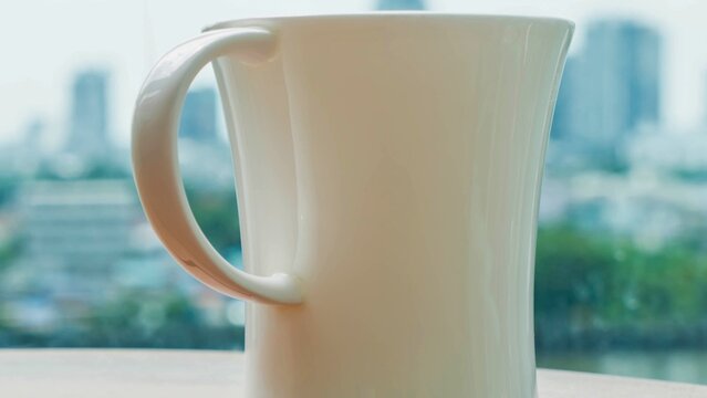 Tall white ceramic pitcher on a table with city view - Powered by Adobe