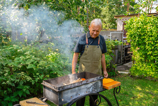 Man preparing barbecue in a lush garden setting