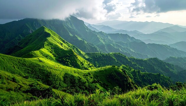 A breathtaking panoramic view of rolling green mountains under a dramatic sky with sunbeams.
