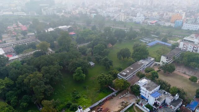 4K Aerial Drone View of Hazy Urban Cityscape with Green Trees and Buildings in Heavy Smog.
