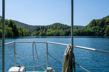Railing of a boat on a lake with forest