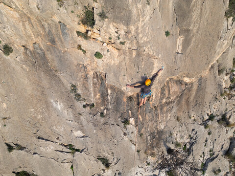 Climber navigating a steep rock face with safety gear