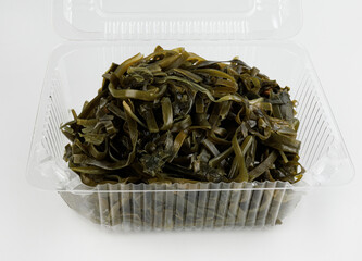 Seaweed in a plastic container on a white background.
