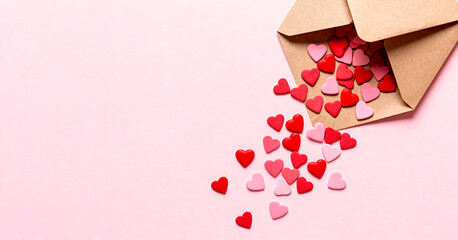 A banner with an empty space for text.The envelope is decorated with small red and pink confetti in the shape of hearts on a light pink background.