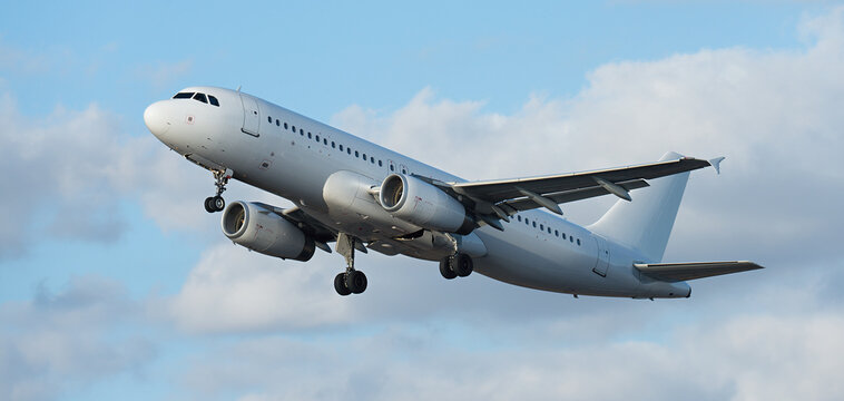 Airplane take off on the blue sky, with white clouds. Aircraft flying on sky background. White passenger jet plane in the blue sky. Low angle view of Airplane flying under blue sky, with white clouds