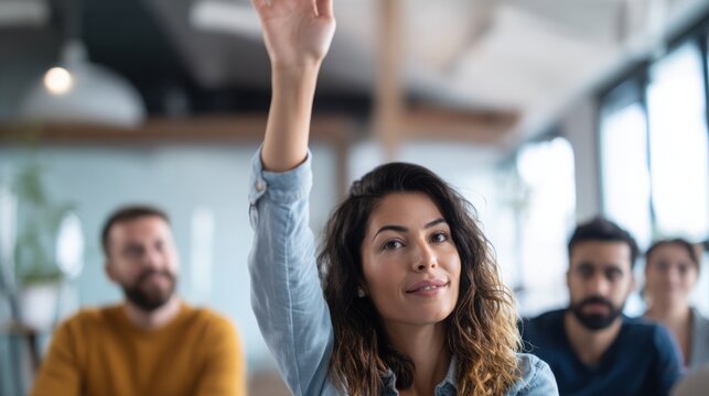 close up of an employee raising hand during a collaborative team meeting in a modern office, minimalist interior, blurred coworkers and screen