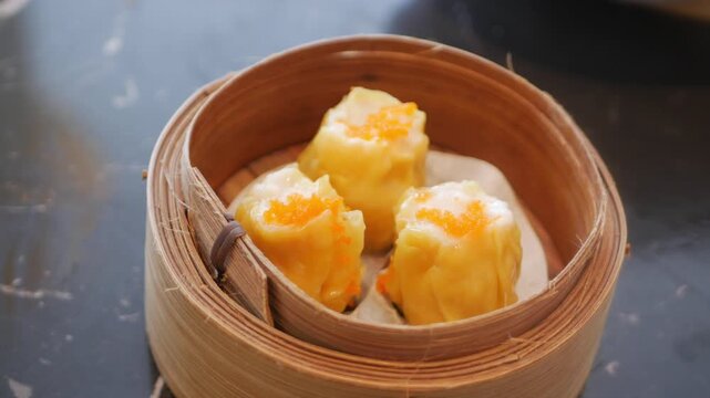 close up view to a steamer full with suimai dimsum in hongkong style with hot streaming ready to eat with panning view,chinese dimsum food eating