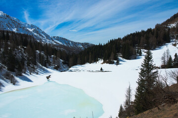 Alpine view with mountains and frozen lake Lago del Prato. Carona, Orobie Alps, Lombardy, Italy