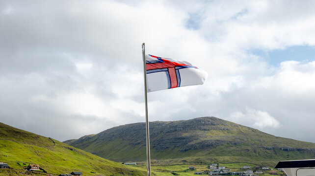Faroe Islands flag fluttering in Mykines landscape