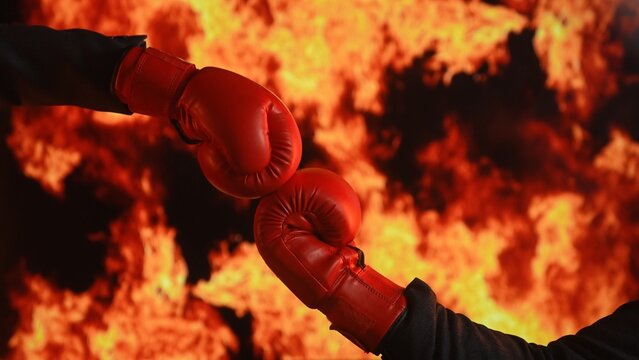 Red Boxing Gloves Against Fiery Background