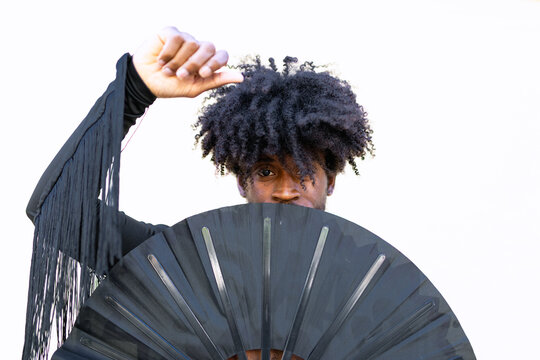Black man with afro hair dancing with fan