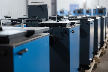 Industrial machinery lined up in a spacious workshop with blue and gray designs