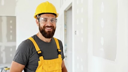 Happy construction worker talking to the camera and giving a thumbs up. Professional builder presenting finished drywall work. Home improvement and renovation service concept