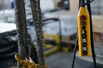 Control panel and lifting straps in an industrial setting showcasing heavy machinery operation