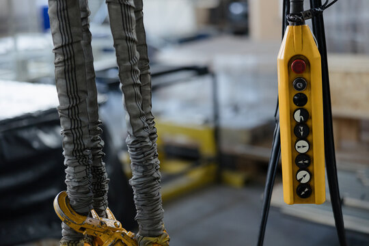 Control panel and lifting straps in an industrial setting showcasing heavy machinery operation