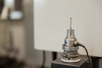 Precision measuring tool resting on a machine in a modern workshop setting