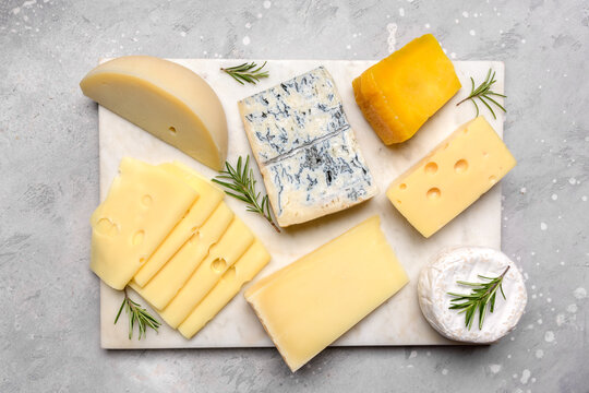 Italian and French gourmet cheese platter with craft cheese assortment on a marble platter. hard cheeses, mold cheese, gorgonzola, pecorino, Emmental, Roquefort cheddar